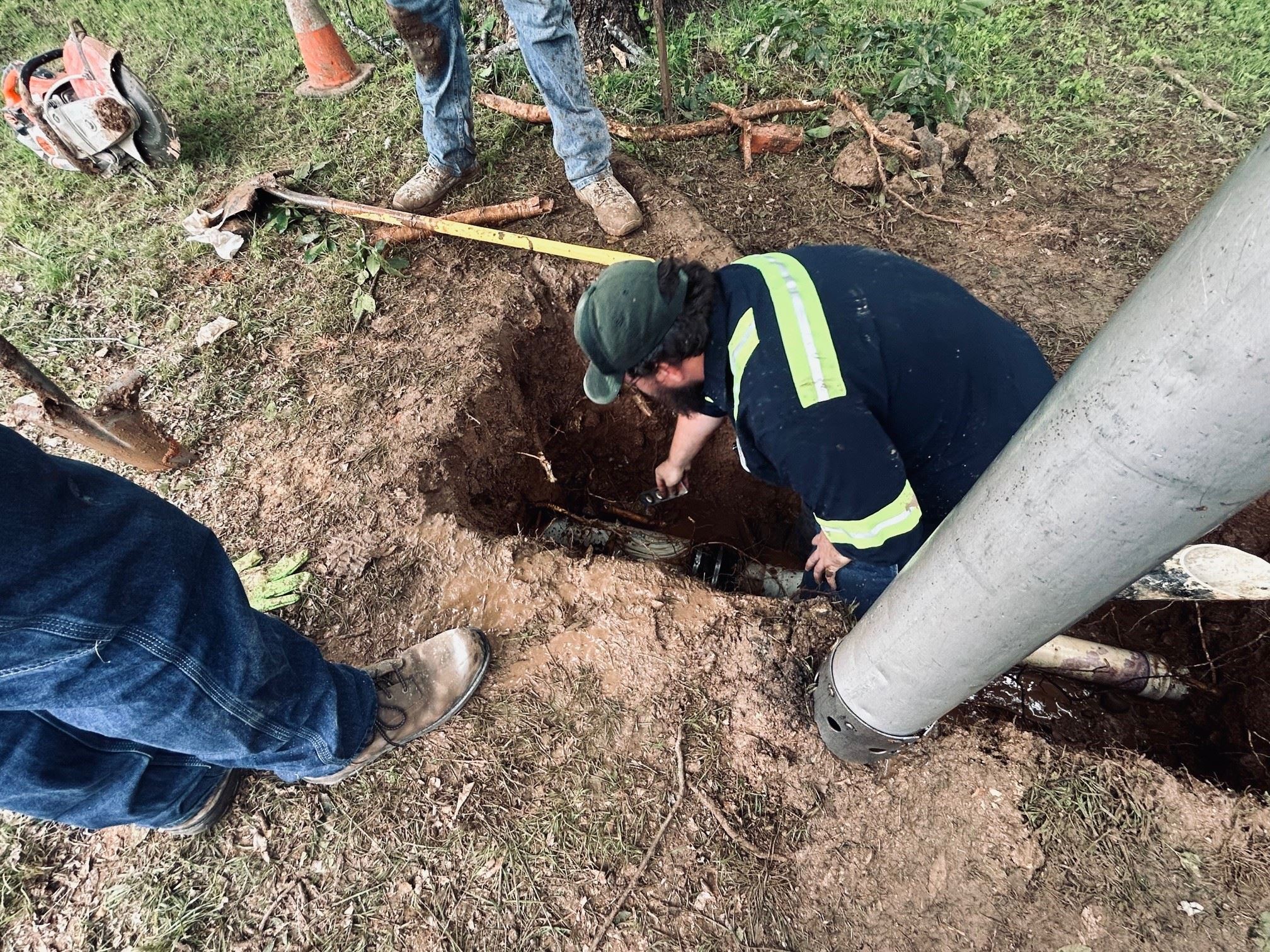 A City Wastewater Collection worker working in a ground hole.
